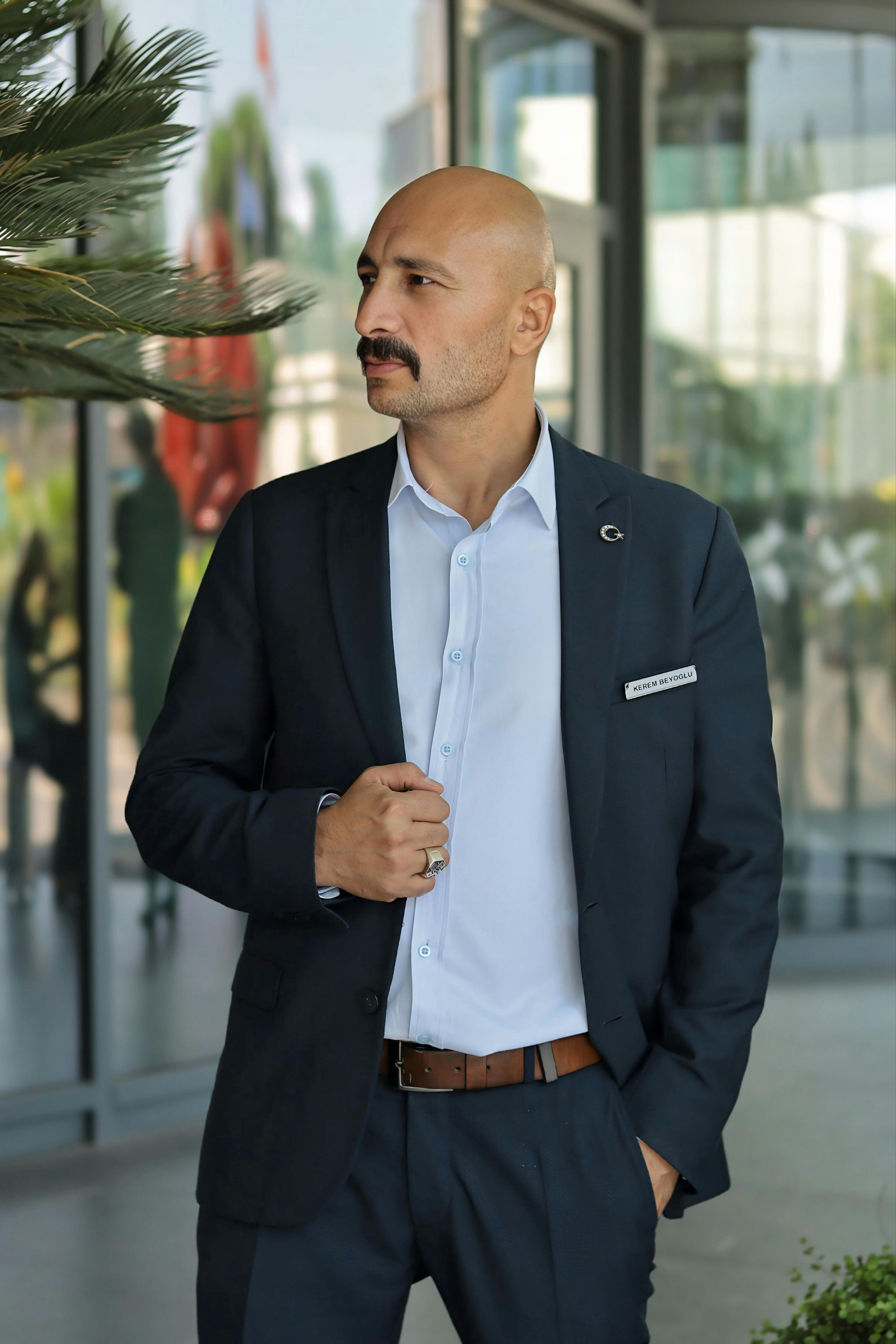 Portrait of a confident businessman in a formal suit standing in a modern office environment.