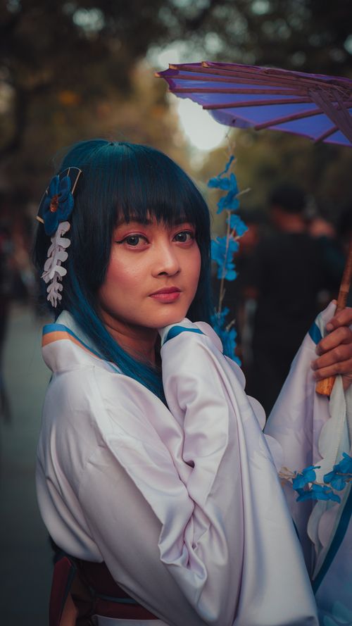 Free Captivating cosplay portrait featuring a young woman with parasol, set in a soft ambient atmosphere. Stock Photo