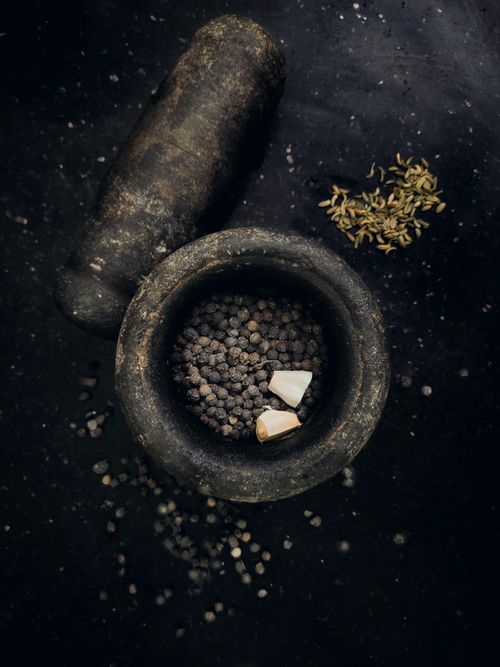 Free Flat lay of rustic stone mortar and pestle with peppercorns and spices. Stock Photo