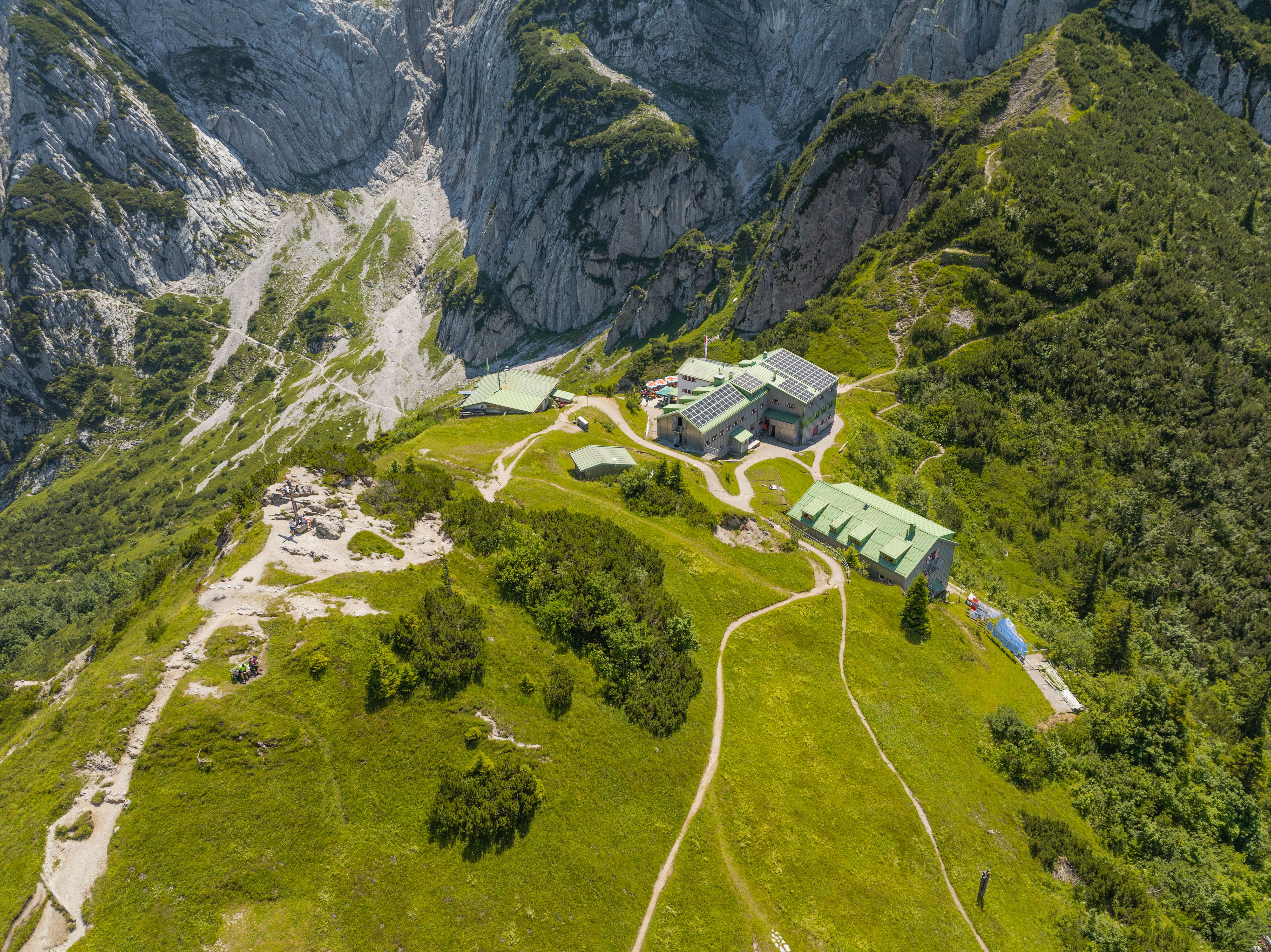 A picturesque aerial view of a mountain retreat nestled among rocky cliffs and green valleys.