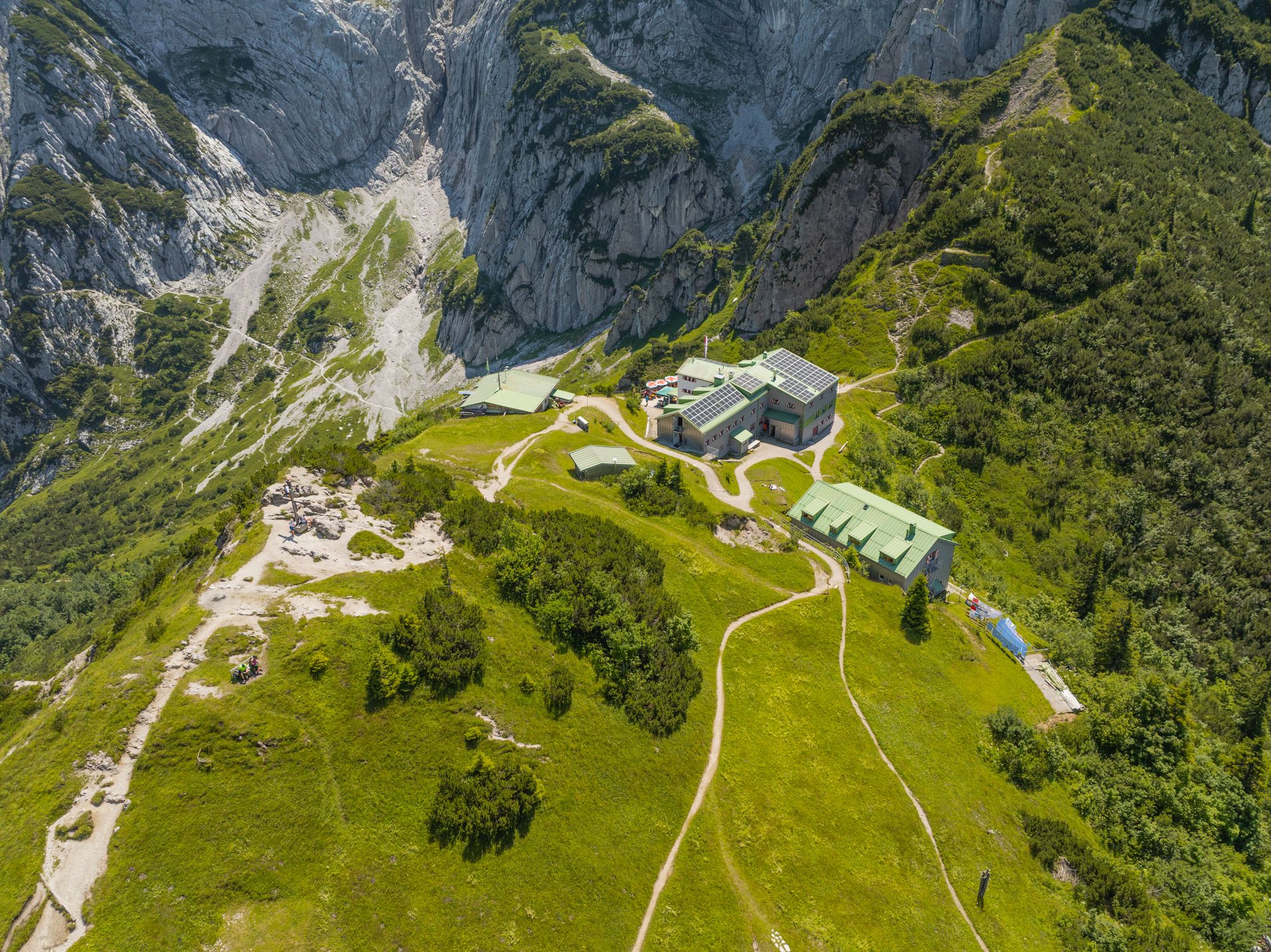 A picturesque aerial view of a mountain retreat nestled among rocky cliffs and green valleys.