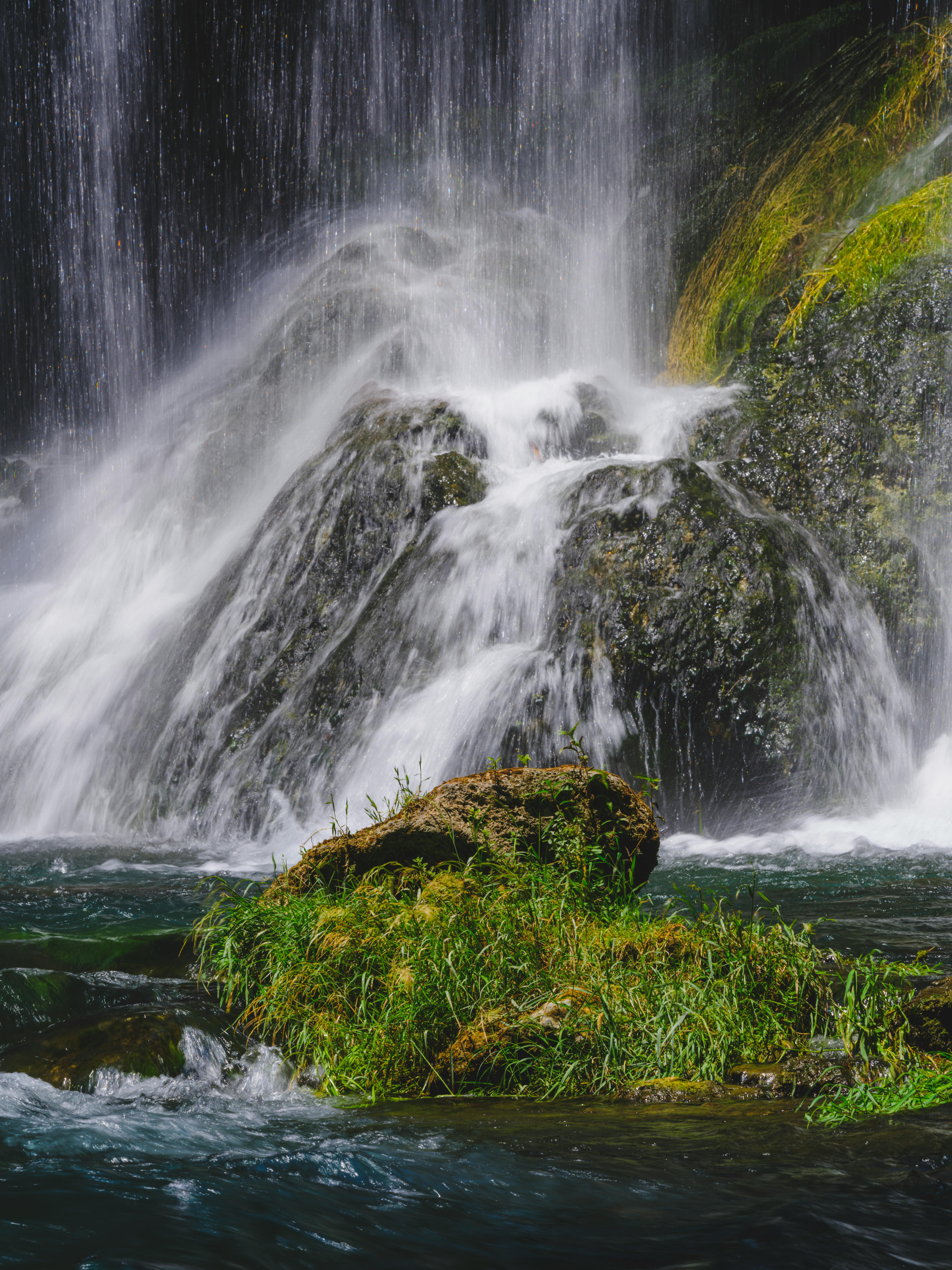 serene waterfall over verdant rocks in a forest
