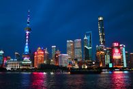 上海城市景观充满活力，标志性的摩天大楼在夜间倒影中熠熠生辉