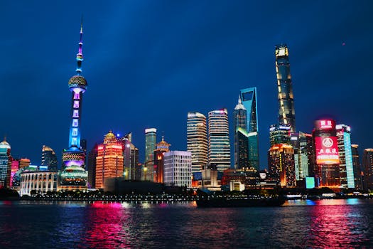 Vibrant Shanghai cityscape featuring iconic skyscrapers illuminated during nighttime reflection.