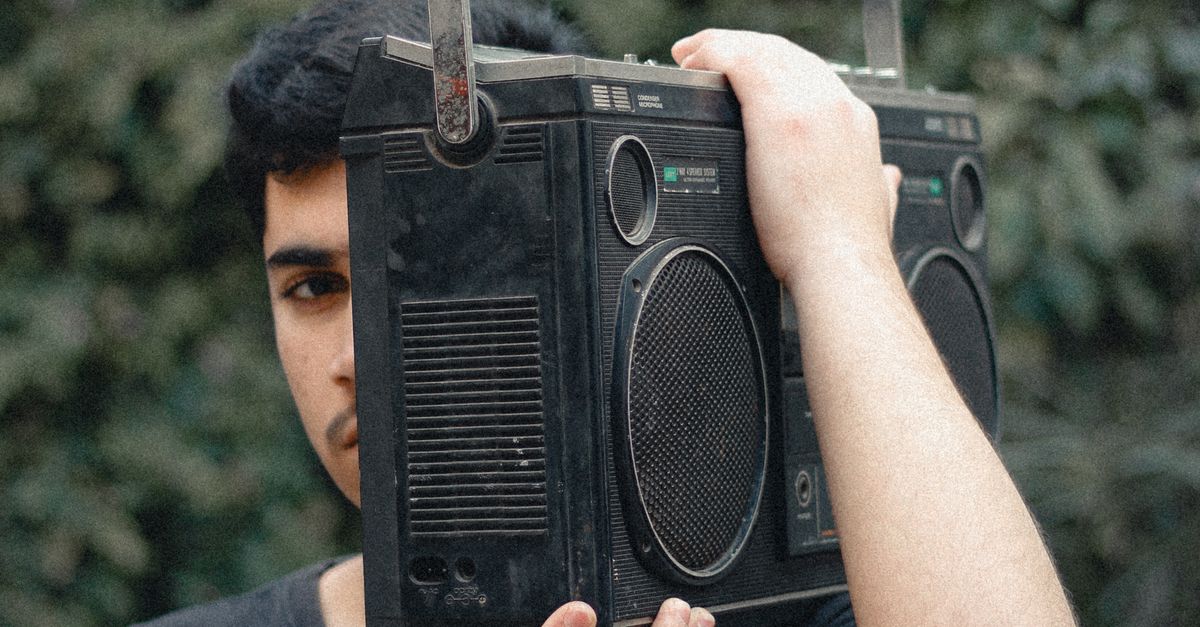Guy Using Radio Young Man with Vintage Radio in Outdoor Setting · Free Stock Photo