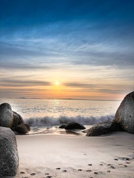 A tranquil sunset at a rocky beach in Western Cape, South Africa, showcasing the serene ocean waves.
