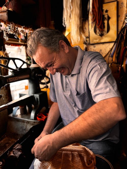 Free Smiling craftsman working in a cozy workshop, surrounded by tools and materials. Stock Photo