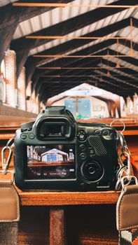A DSLR camera captures detailed images inside a rustic wooden church interior with vaulted ceilings.