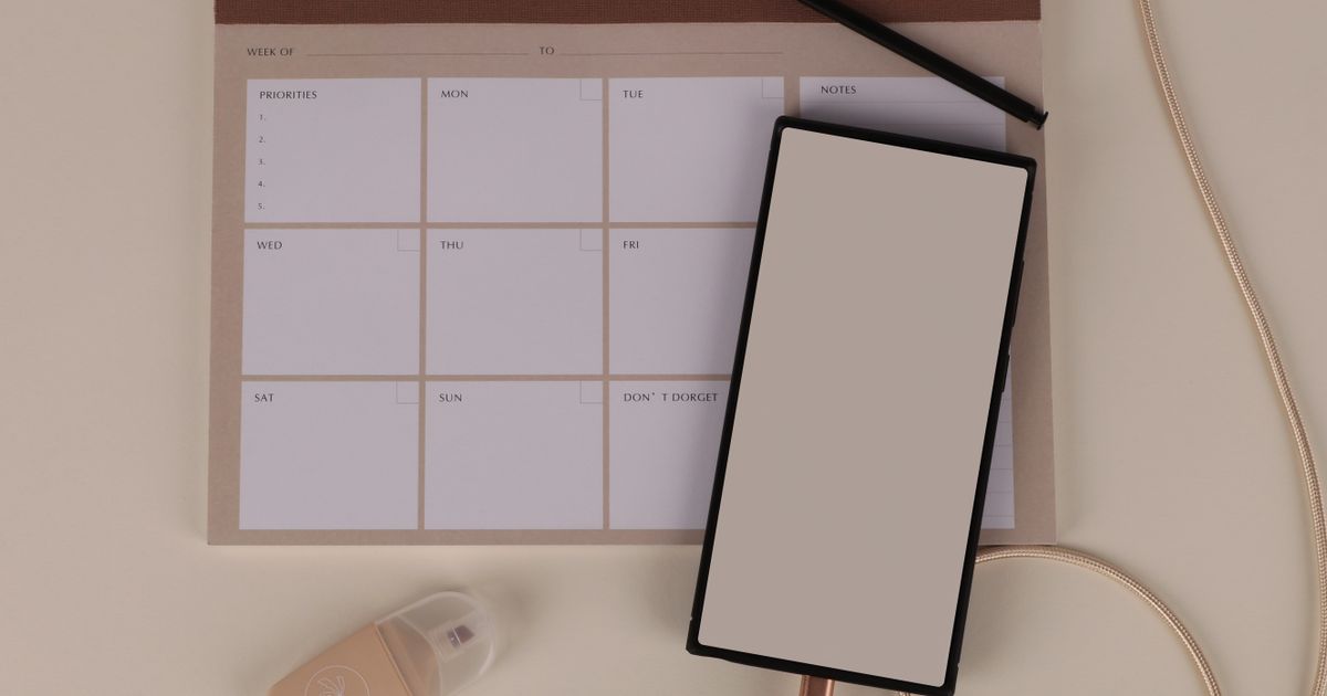 Weekly planner and stationery laid out on a modern desk