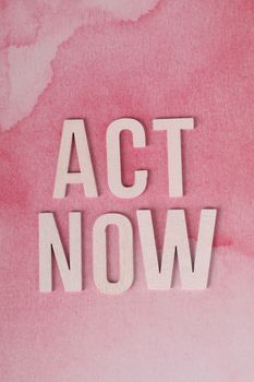 Motivational text "Act Now" on a pink watercolor backdrop, encouraging immediate action.