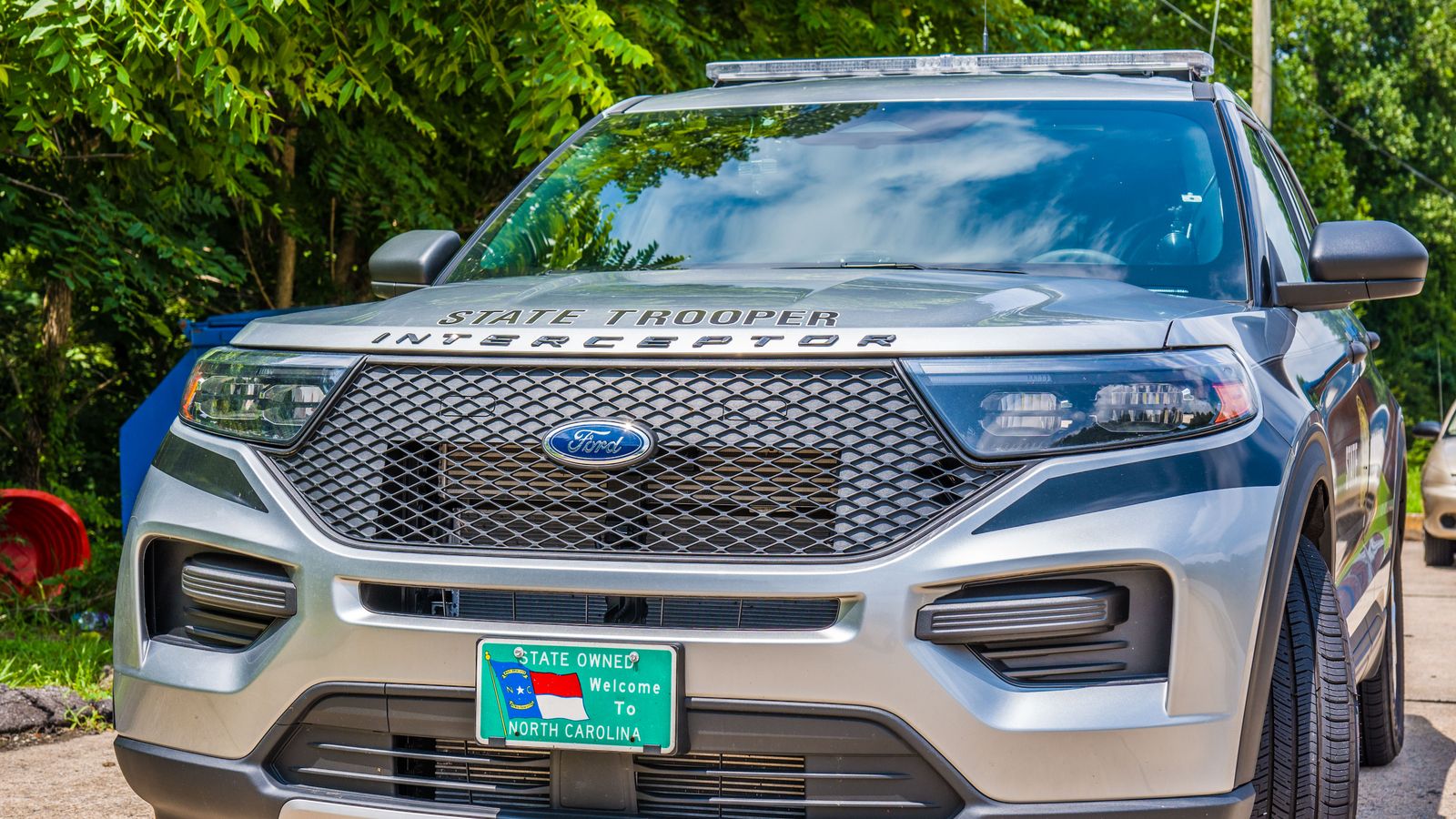 A state trooper SUV parked outdoors in summer weather, showcasing law enforcement presence.
