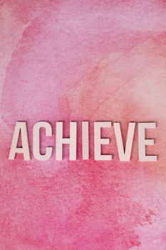 Motivational word 'achieve' on a vibrant pink watercolor background.