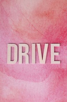 Lettering spelling 'DRIVE' on a pink watercolor backdrop, symbolizing motivation and energy.
