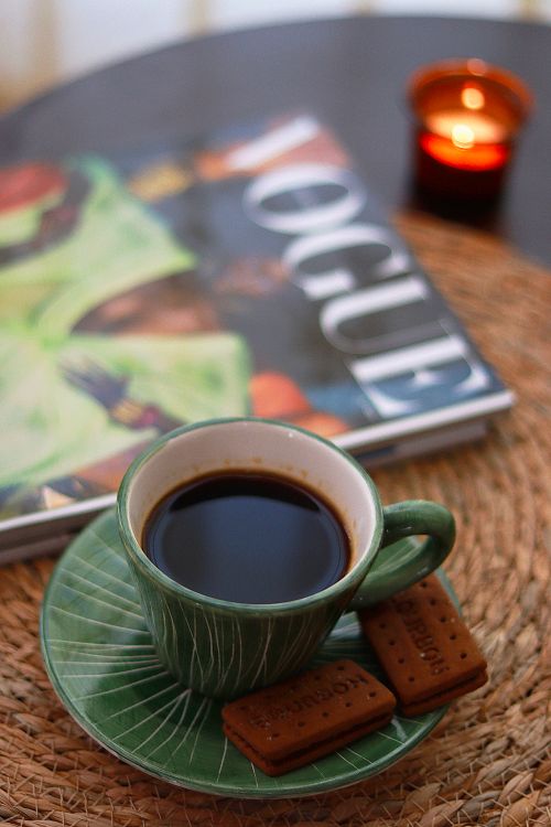 Free Enjoy a cozy afternoon with a cup of coffee, biscuits, and a fashion magazine on a wicker mat. Stock Photo
