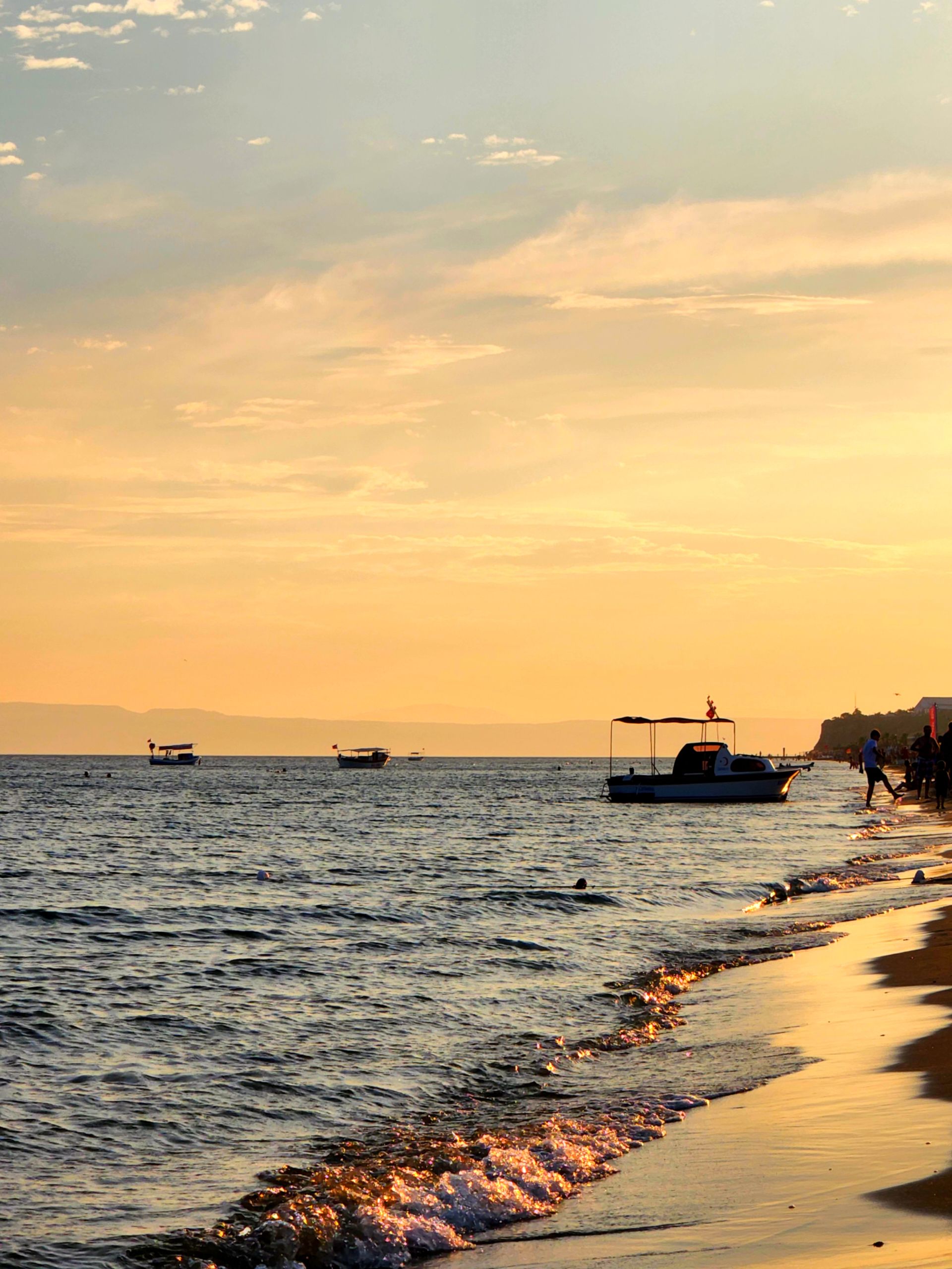 Golden Sunset on Calm Beach with Boats · Free Stock Photo