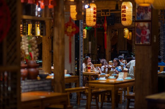 Atmospheric shot of people dining in a traditional Asian restaurant with warm lighting.