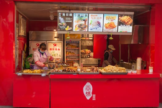 Vibrant street food stall with cooks preparing delicious traditional dishes.