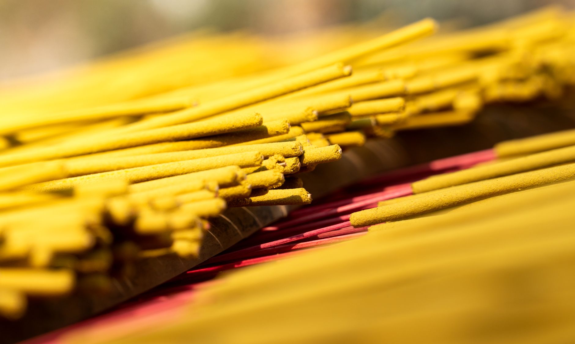 Close-up of handcrafted vibrant yellow incense sticks in Vietnam, highlighting cultural spirituality.