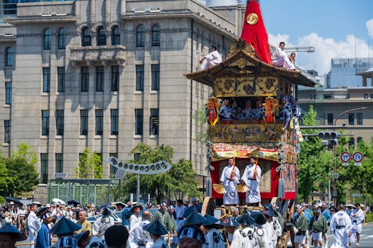 Colorful festival float with participants in traditional attire during a sunny parade in Japan.