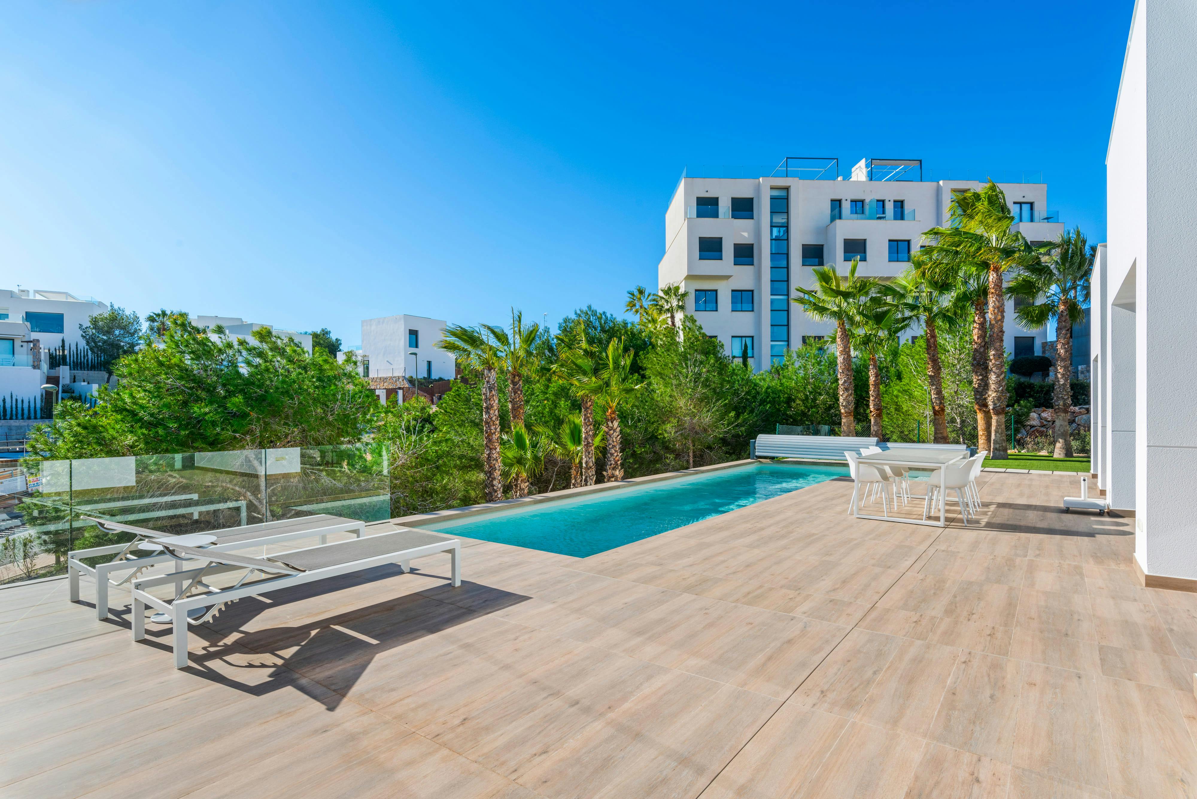 Elegant poolside terrace with palm trees and modern buildings in the background. - Photo by Marshall Real State on Pexels