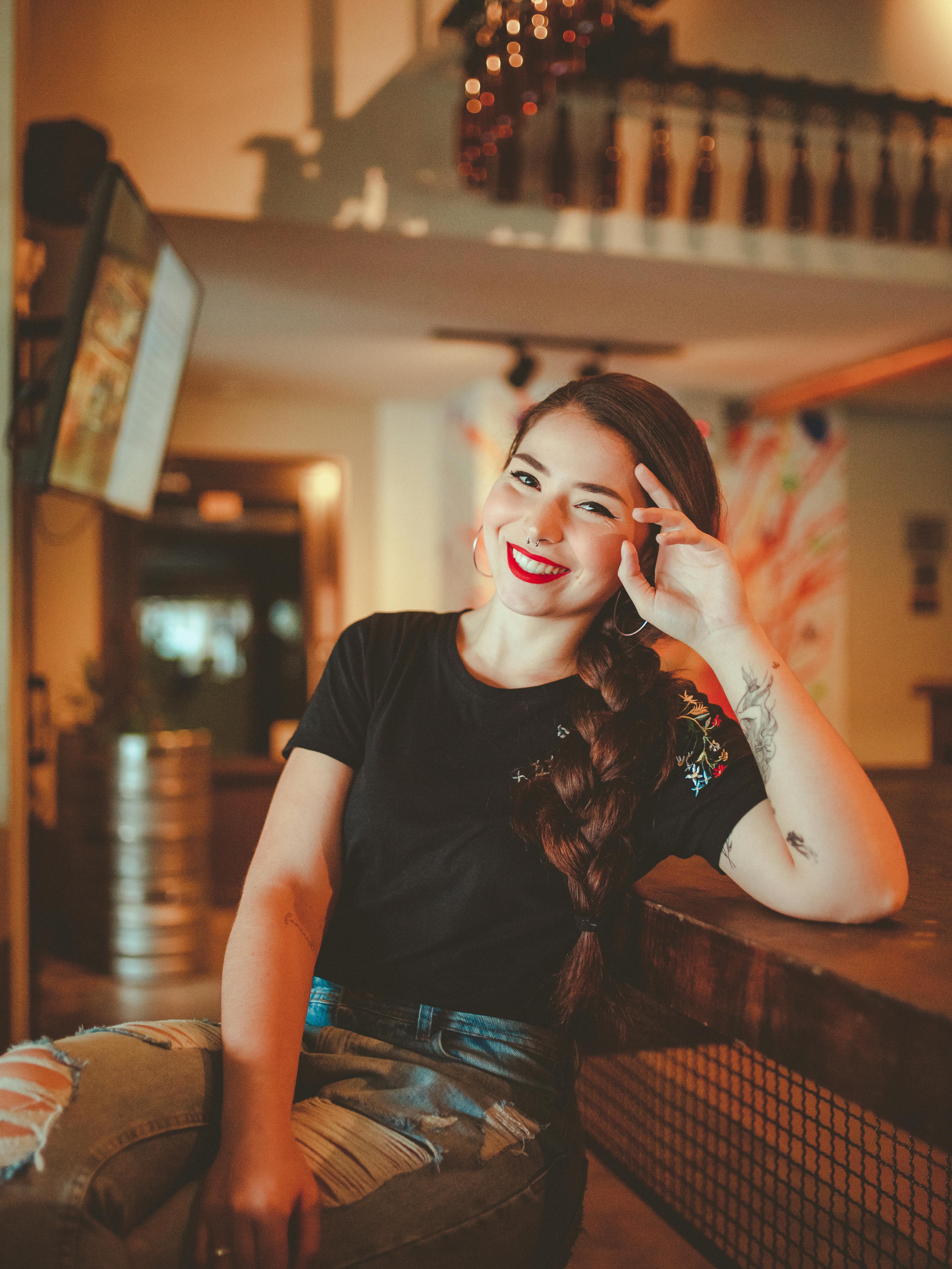 一位女士随意地坐在时尚现代的咖啡馆里，面带微笑