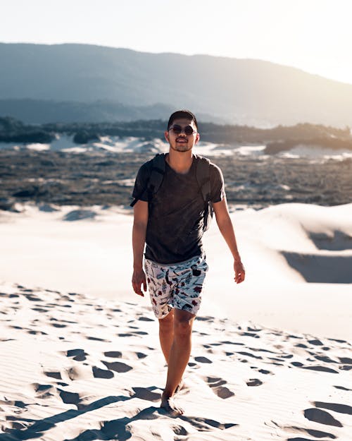 Man Walking Barefoot on Sand