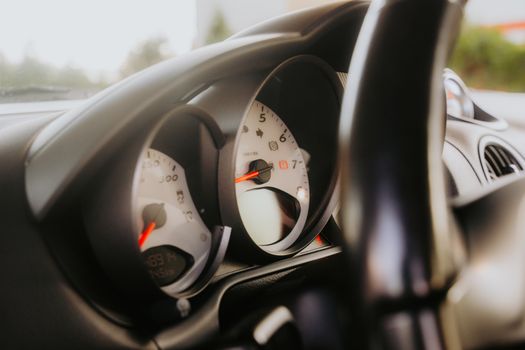 Detailed view of a car's dashboard displaying the speedometer and tachometer.