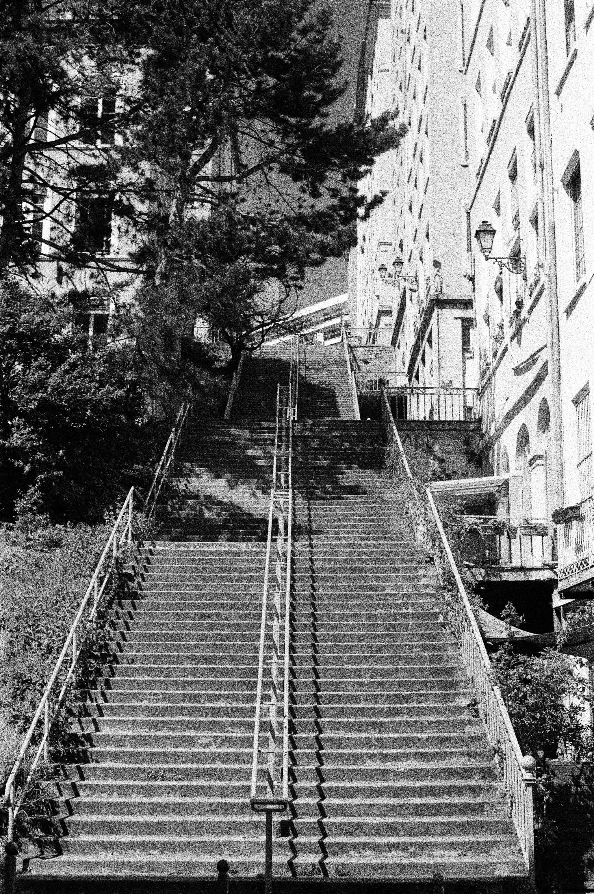 Escalier emblématique de la Croix-Rousse en noir et blanc, ambiance de quartier populaire lyonnais