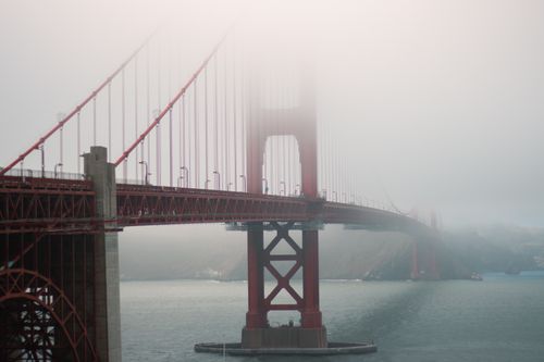 Free Atmospheric view of the Golden Gate Bridge enveloped in fog, showcasing its iconic design. Stock Photo