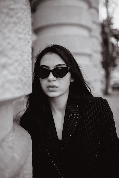 Free Black and white portrait of a woman wearing dark sunglasses, exuding a moody and stylish vibe outdoors. Stock Photo