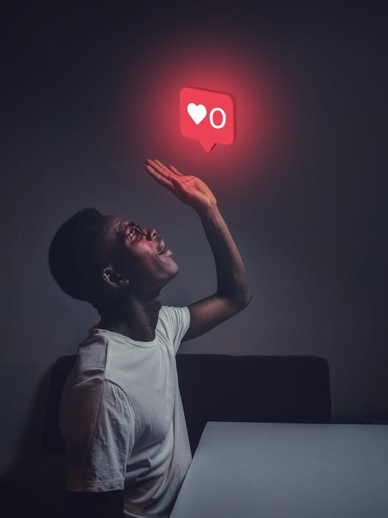 A man looking up at a social media symbol floating above him