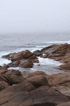 Fog envelops the rocky coast of St. John's, Newfoundland, creating a serene seascape.. envelops, rocky, coast