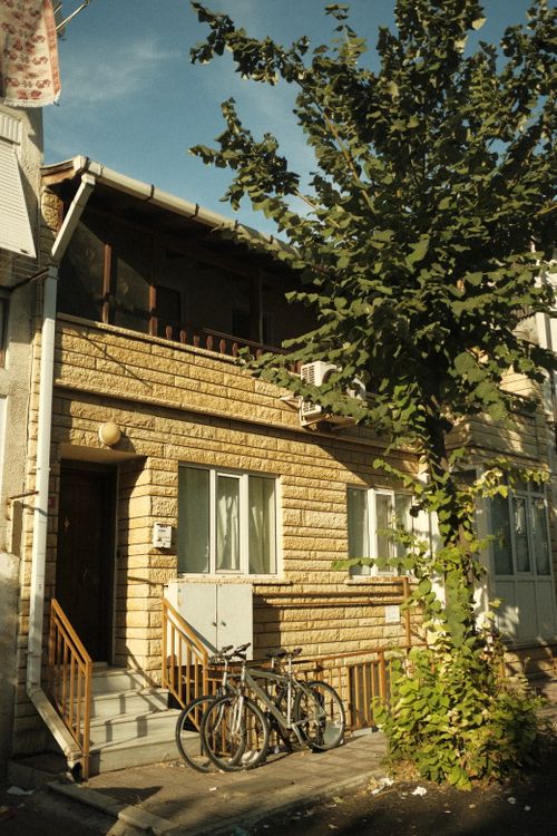 Free Bicycles leaning against a sunlit house on a leafy street in Buyukada, İstanbul, Türkiye. Stock Photo