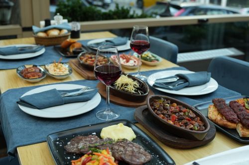 Free A beautifully set table in a restaurant with various dishes and glasses of red wine, perfect for fine dining. Stock Photo