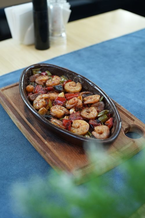 Free Savor the taste of grilled shrimp with bell peppers, served on a rustic wooden tray, perfect for a gourmet meal. Stock Photo