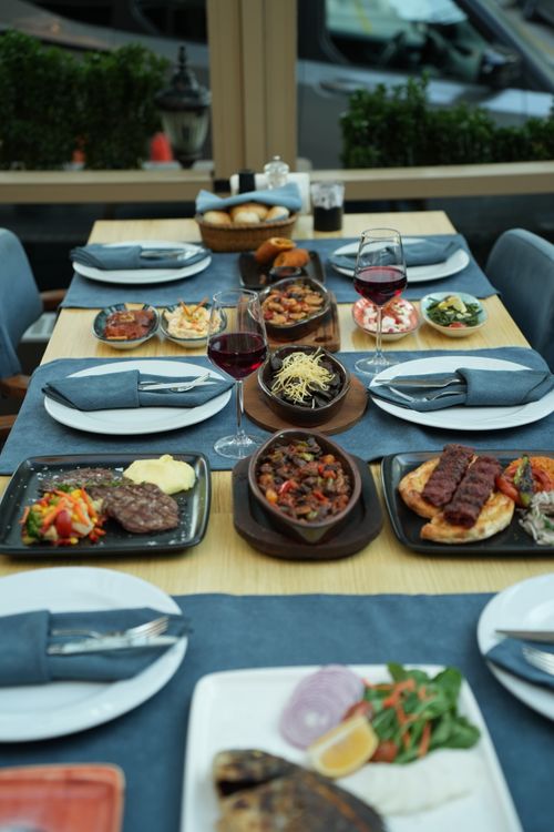 Free A beautifully presented dining table set with an array of gourmet dishes and glasses of wine in a restaurant setting. Stock Photo