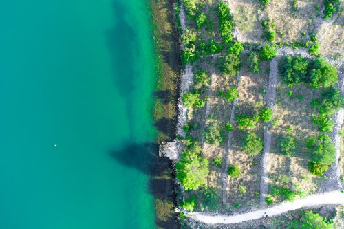 Free Serene aerial view of a vivid coastal landscape with lush greenery and turquoise water. Stock Photo