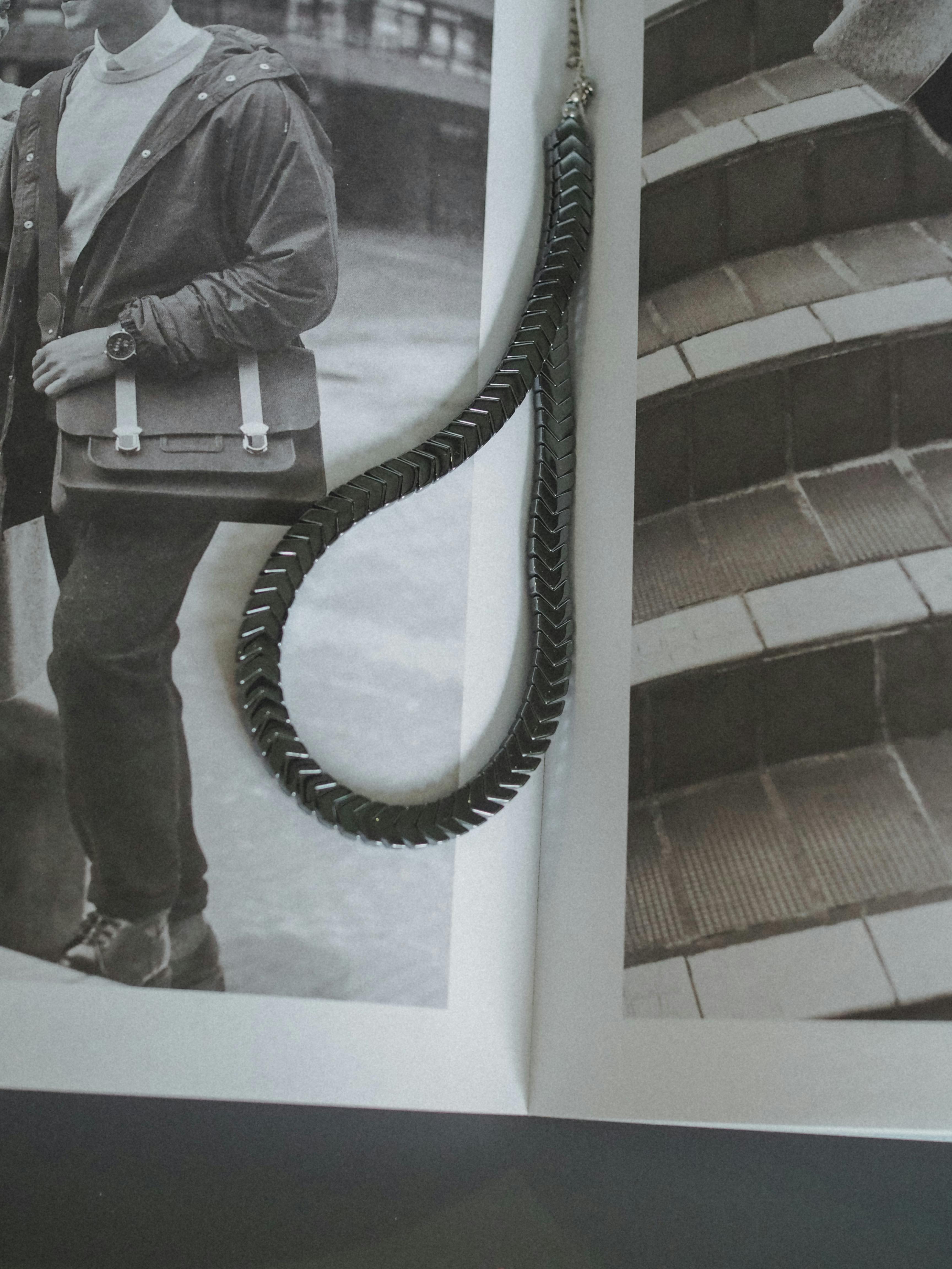 Gratis Raffinata collana nera elegantemente drappeggiata su un servizio di una rivista moderna che mostra moda e architettura. Foto a disposizione