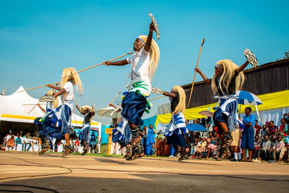 Bailarines Intore con tocados blancos saltando en una ceremonia tradicional ruandesa