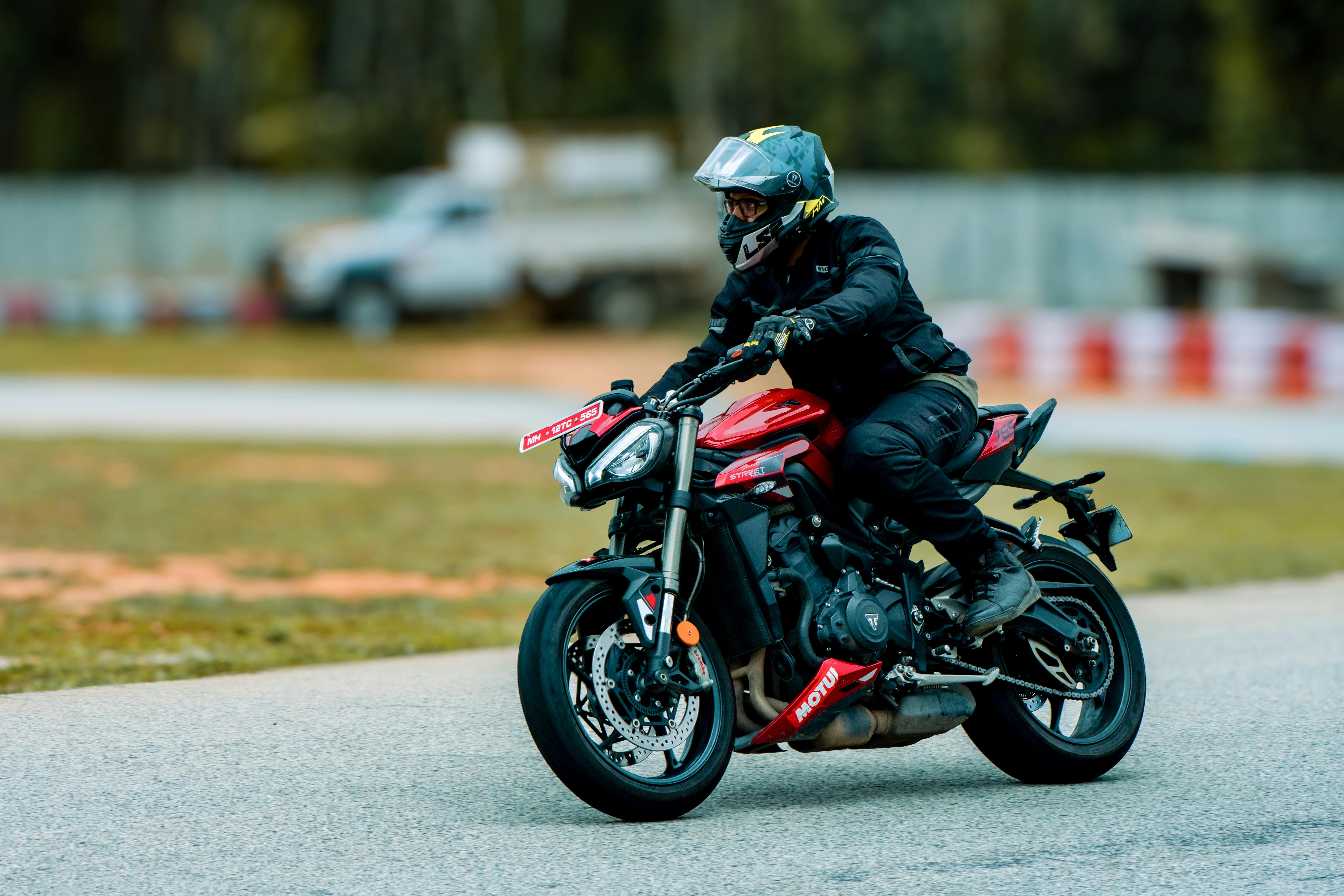 Motorcyclist in gear races on outdoor track in Bengaluru, India.