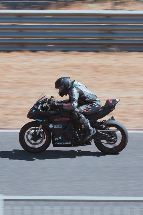 Free Motorcyclist speeds on a track in full gear showcasing agility and precision. Stock Photo