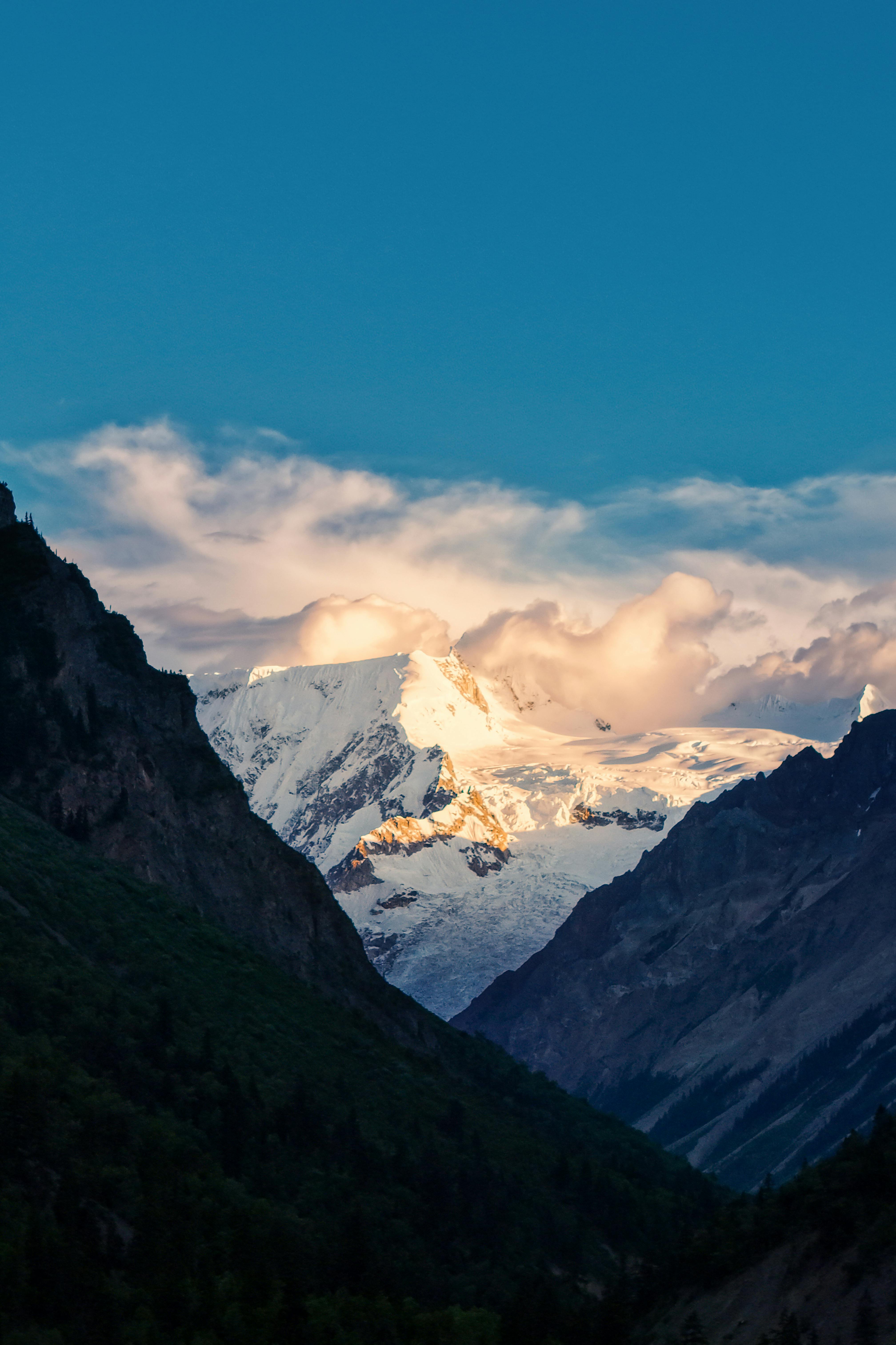 Breathtaking view of snow-covered mountains in Tibet under a vibrant blue sky, a perfect travel destination.