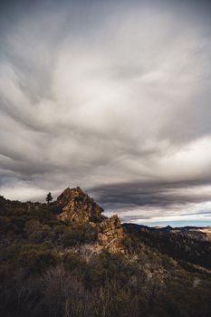 暴风雨云笼罩在崎岖的岩石山脉上空，展现了大自然的力量