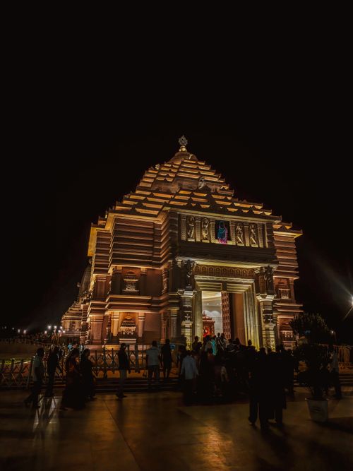 Free Night view of an ornately lit Hindu temple in Digha, India, with visitors gathered. Stock Photo