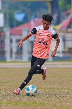 Young soccer player in action during a daytime outdoor match.