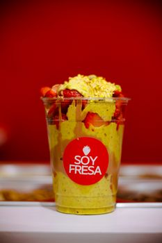 Vibrant strawberries and cream dessert in a 'Soy Fresa' cup.