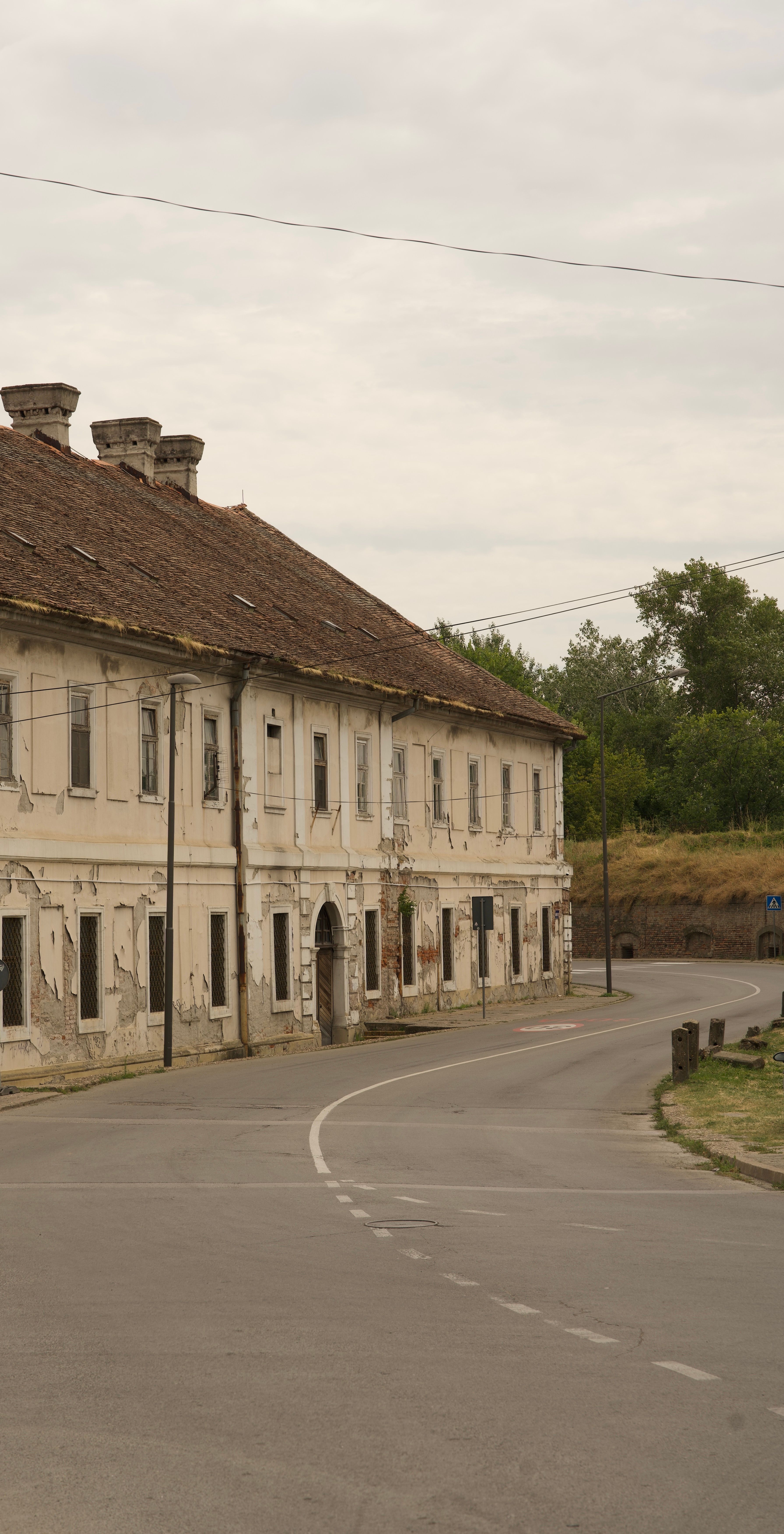 Abandoned European-style building on a curved empty street.