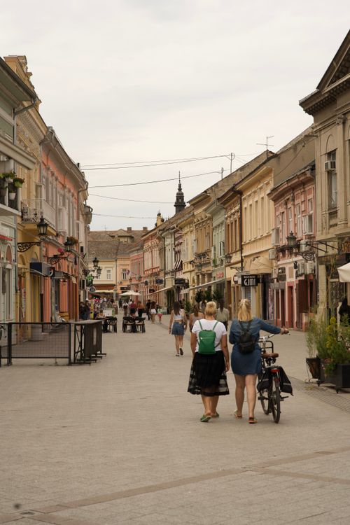 Free A picturesque pedestrian street in a European city with vibrant architecture and people strolling. Stock Photo