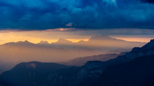 Free Breathtaking view of the French Alps with vibrant sunset hues casting dramatic shadows across the landscape. Stock Photo