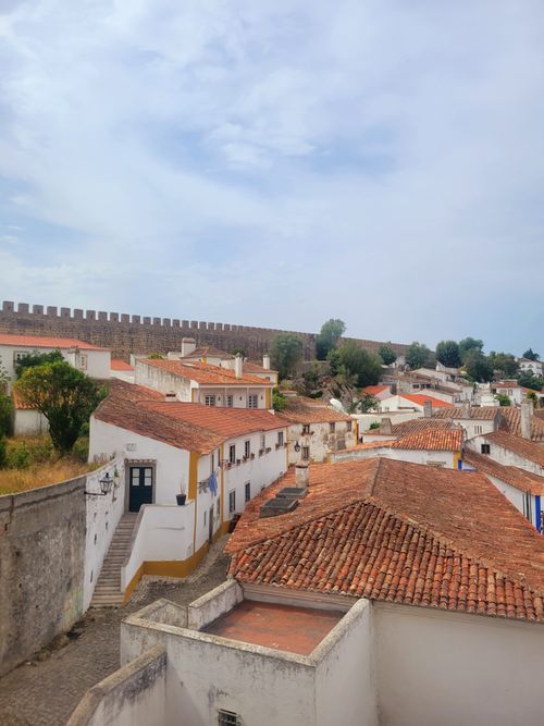 Free Charming view of a medieval village with classic red tiled roofs and ancient stone walls. Stock Photo